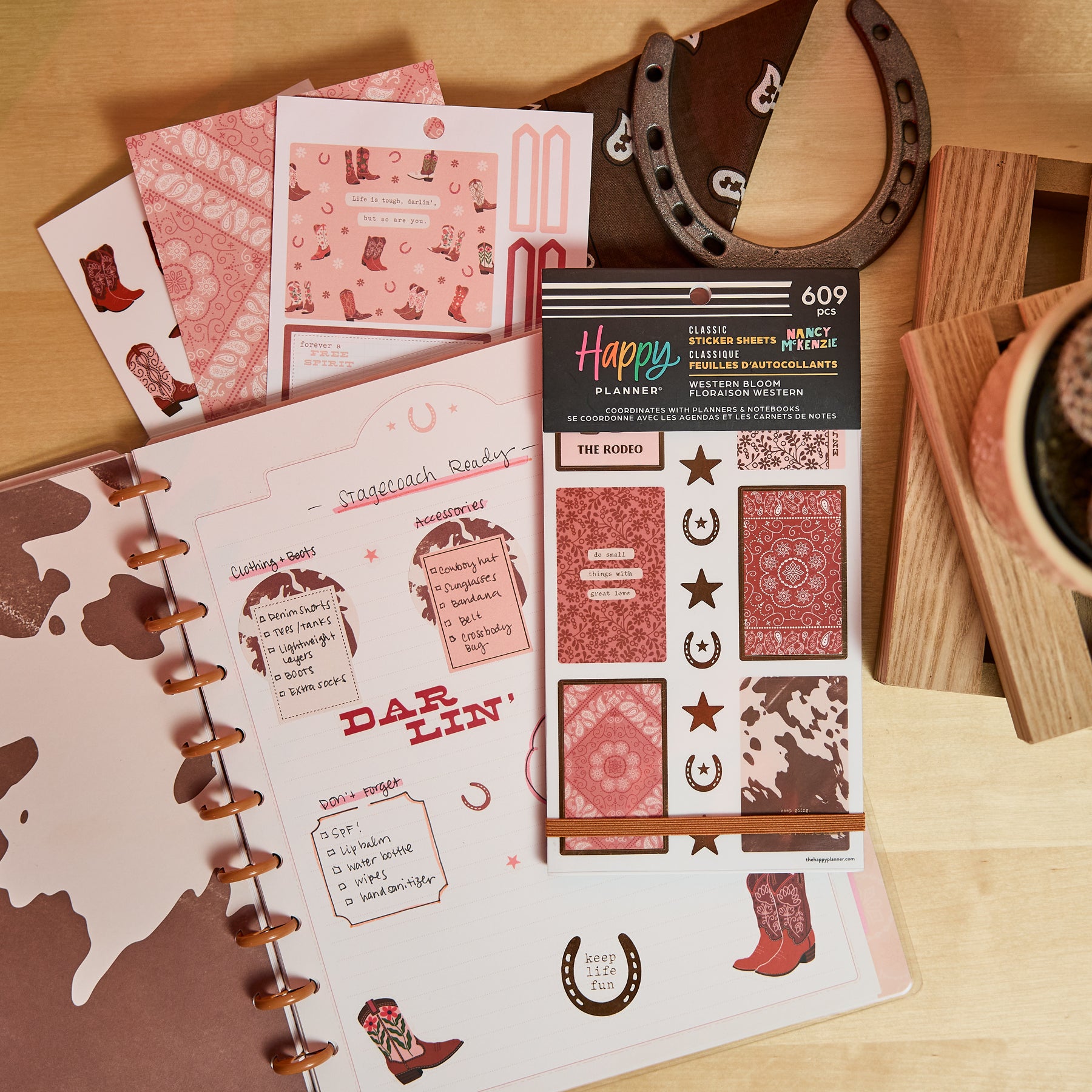 Western Bloom - Value Pack Stickers featuring western-themed designs with boots, horseshoes, stars, and bandana patterns, displayed with a Happy Planner organizer and rustic decor.